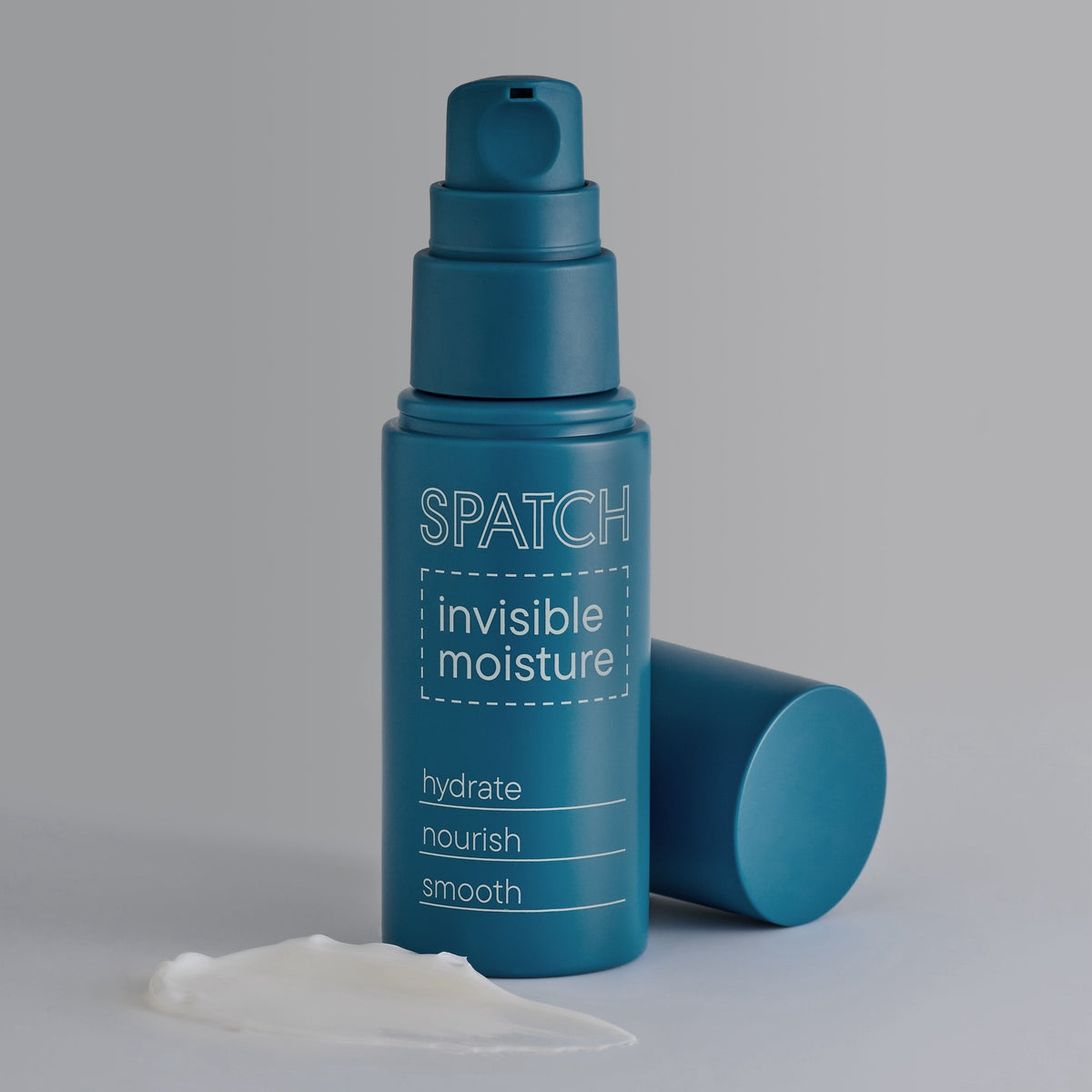 A teal blue pump bottle of SPATCH Invisible Moisture hydrating cream with its cap off lying beside it, and a smear of white cream in the foreground, set against a neutral gray background.